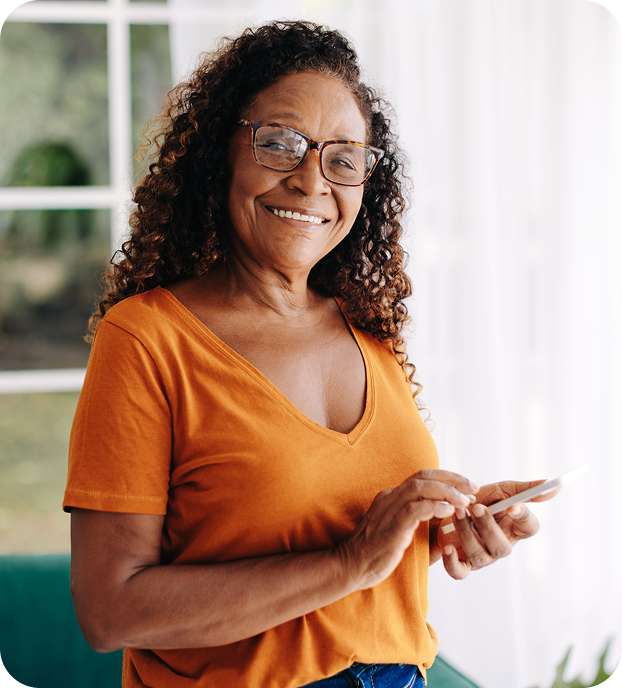 Jotta telesena senhora-com-celular-na-mao-olhando-para-camera